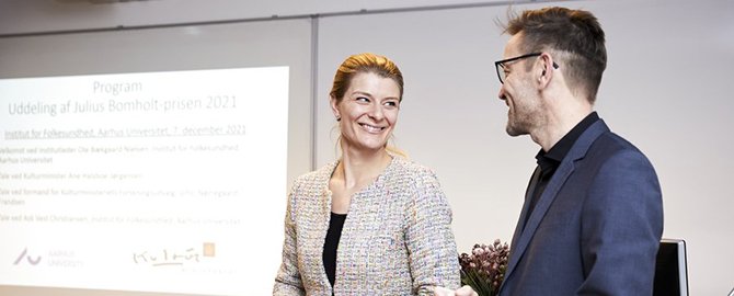 Kulturminister Ane Halsboe-Jørgensen overrakte prisen til Ask Vest Christiansen ved et arrangement på Aarhus Universitet, hvor prismodtagerens kolleger og samarbejdspartnere deltog. Foto: Marjun Danielsen, AU Foto.